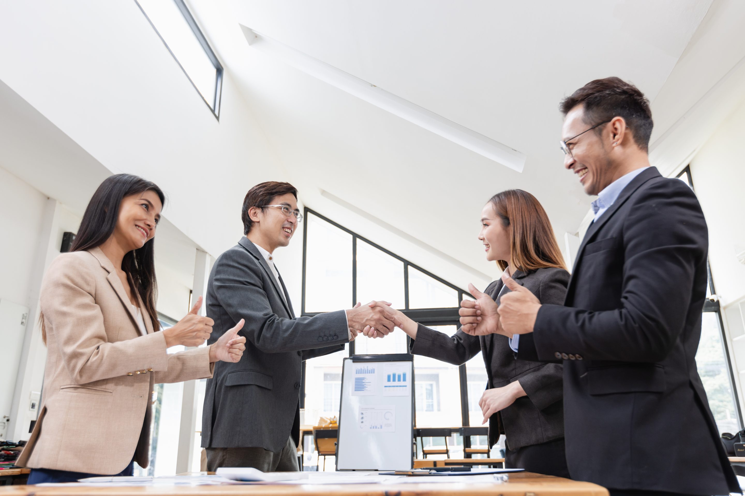 four people interacting inside a meeting room