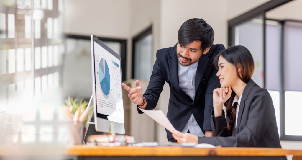 Solving Common Challenges in Sales and Marketing with CRM Solutions marketers looking at a graph