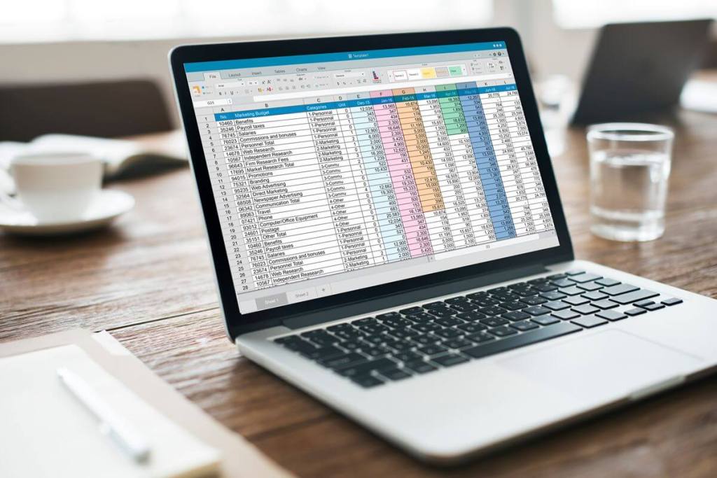 Laptop displaying a large spreadsheet used to manage business data and manual workflows