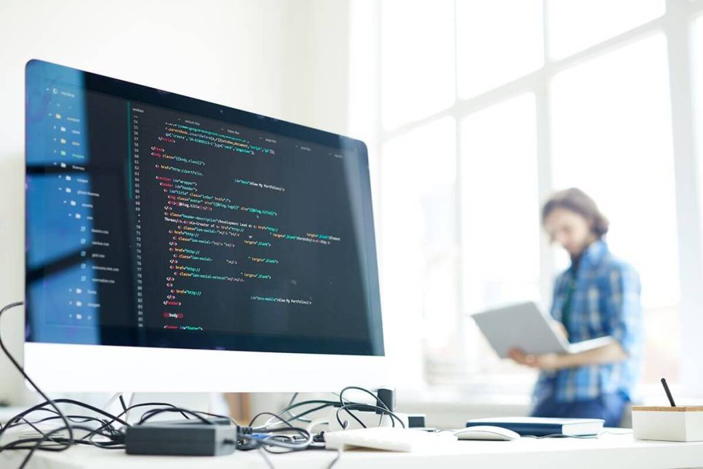 How Custom Software Development Helps Philippine Businesses Automate Processes and Scale Computer monitor displaying code in an office, representing business process automation and custom software development